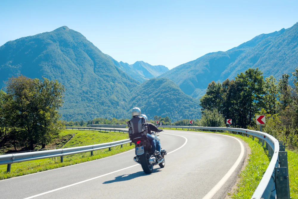 Töff in einer Kurve auf einer Bergstrasse im Sommer